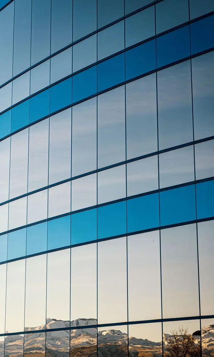 10 productos de limpieza económicos que siempre deberías tener en casa. Ventana de vidrio limpia con reflejo brillante, mostrando el resultado del uso de un limpiavidrios económico.
