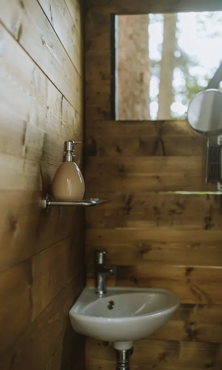 Qué limpiar cada día para evitar el caos en espacios pequeños. Baño pequeño iluminado por luz solar natural que entra por una ventana, con colores claros en las paredes y toallas dobladas ordenadamente.