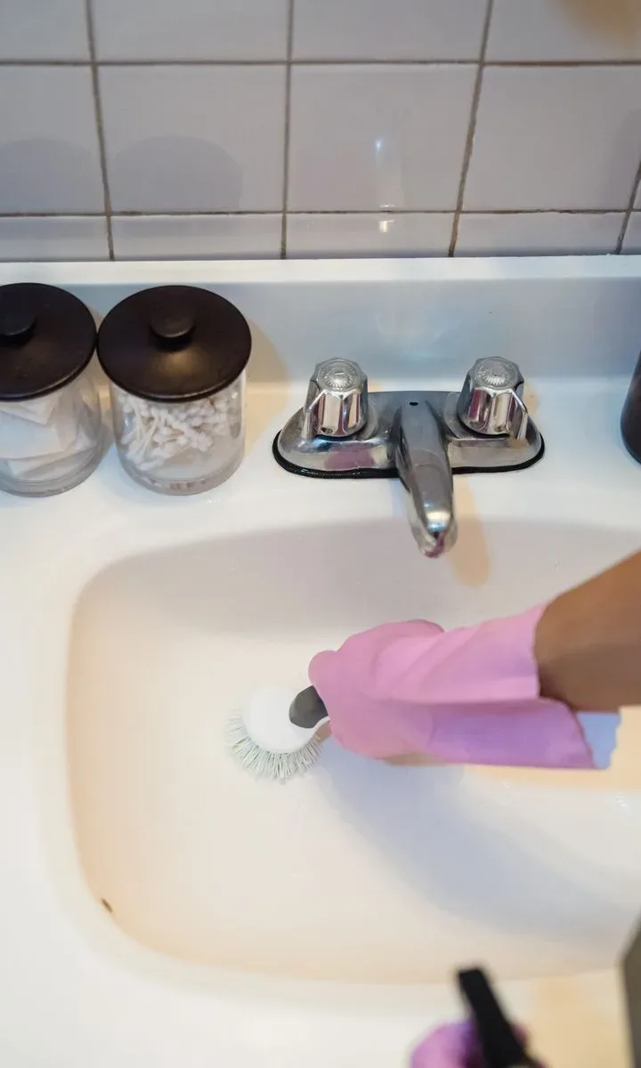 Cómo evitar que tu casa parezca desordenada y sucia Un lavabo de baño impecable con espejo y jabón, sin objetos fuera de lugar, representando la sección de mantener el baño limpio.