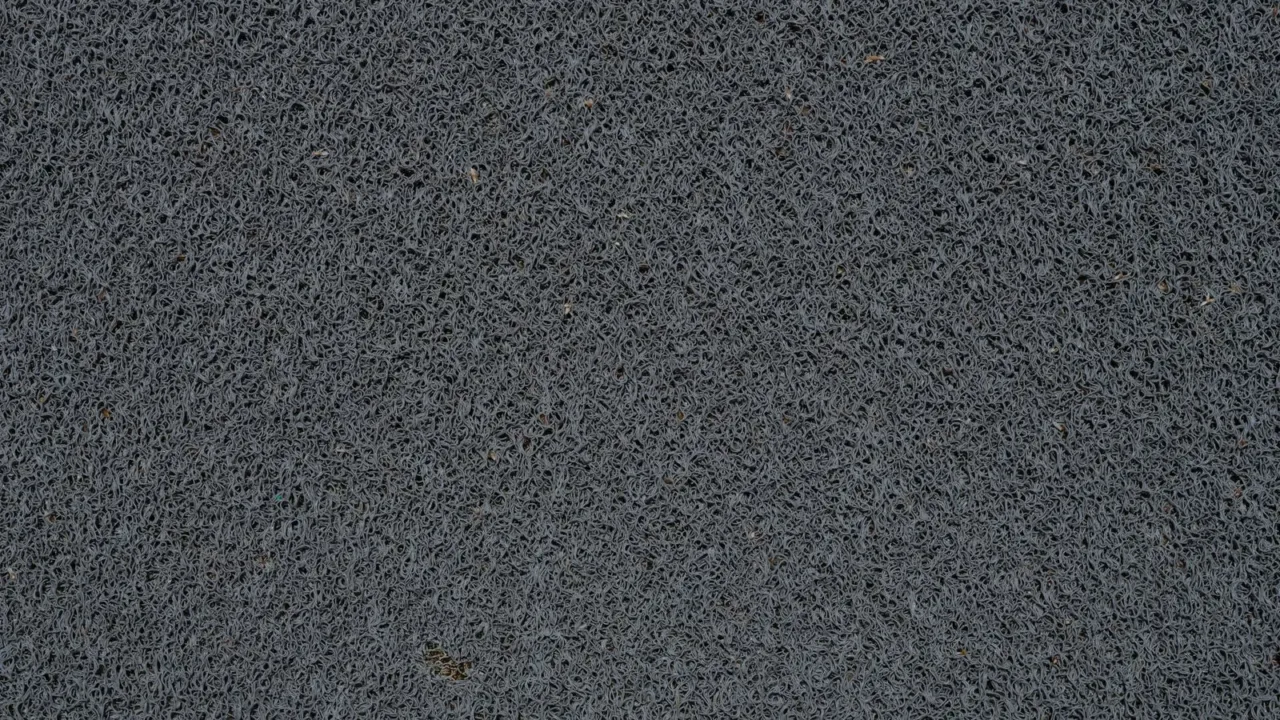Los mejores tapetes para reducir la suciedad que entra desde la calle Primer plano de un tapete de fibra de coco mostrando su textura rugosa ideal para raspar la suciedad de los zapatos.