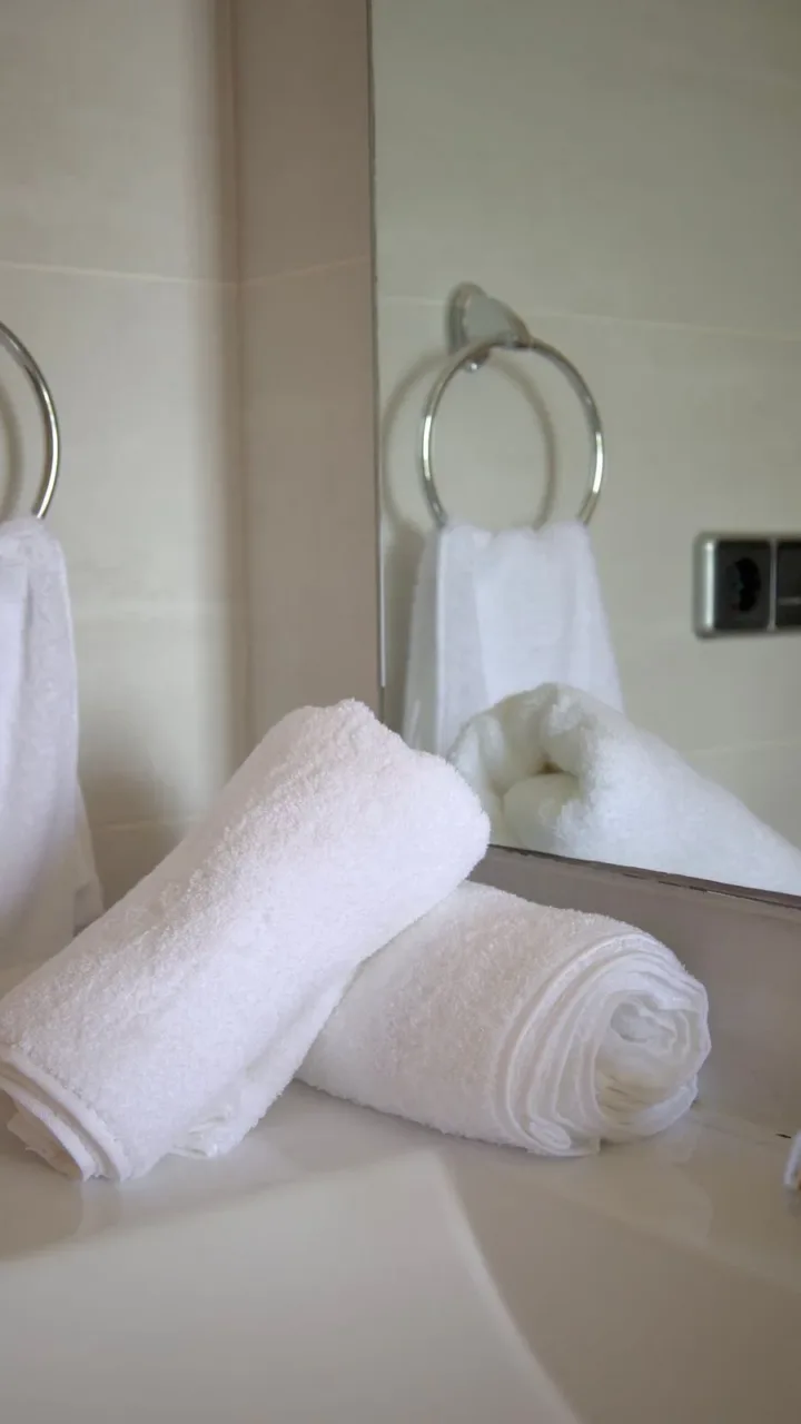 Rutina exprés para departamentos donde vive una sola persona Baño impecable con toallas limpias y productos de limpieza a la vista, mostrando el enfoque del miércoles en la rutina semanal exprés.