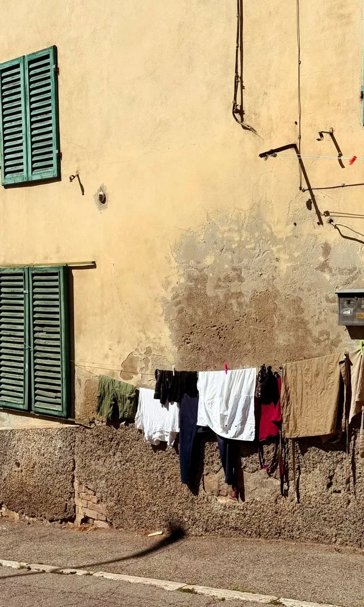 Cómo quitar manchas difíciles de paredes pintadas Una mano sostiene un paño seco para secar una pared pintada después de la limpieza, evitando marcas de agua.