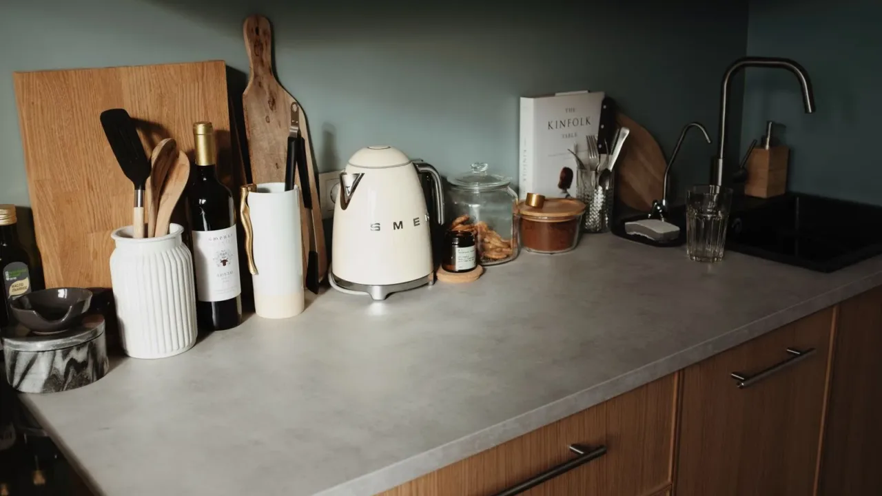 Cómo limpiar vidrios sin dejar marcas usando productos económicos Botellas de vinagre blanco y alcohol isopropílico sobre una encimera, ingredientes económicos para limpiar vidrios.