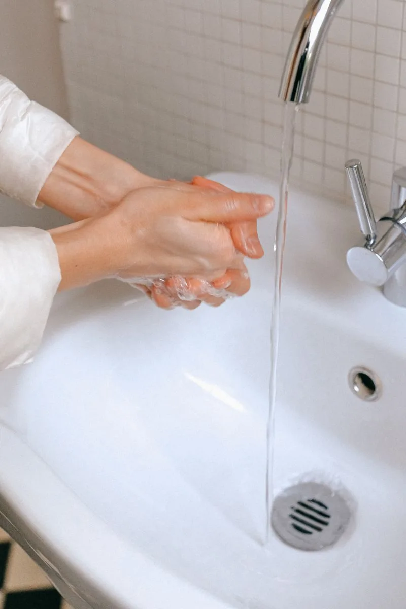 Evitar el moho en el cuarto de baño Un cuarto de baño limpio y seco con azulejos blancos y una ventana abierta para ventilación, representando la prevención del moho.